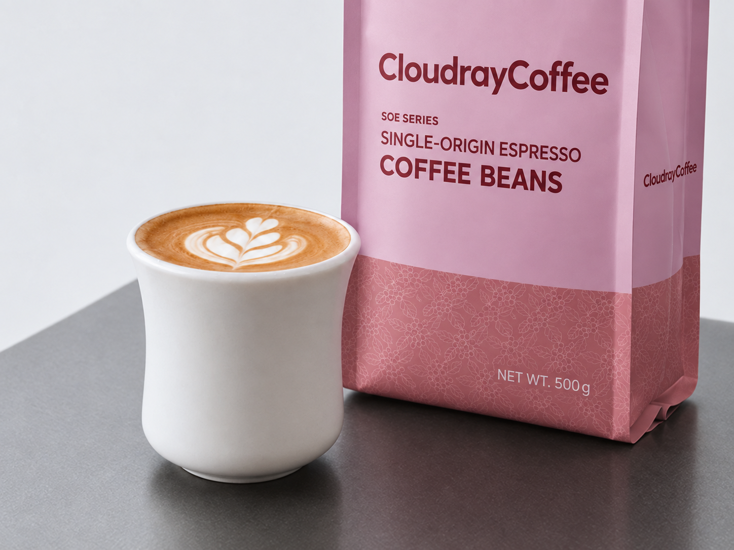 A latte beside a CloudrayCoffee pink SOE coffee bag